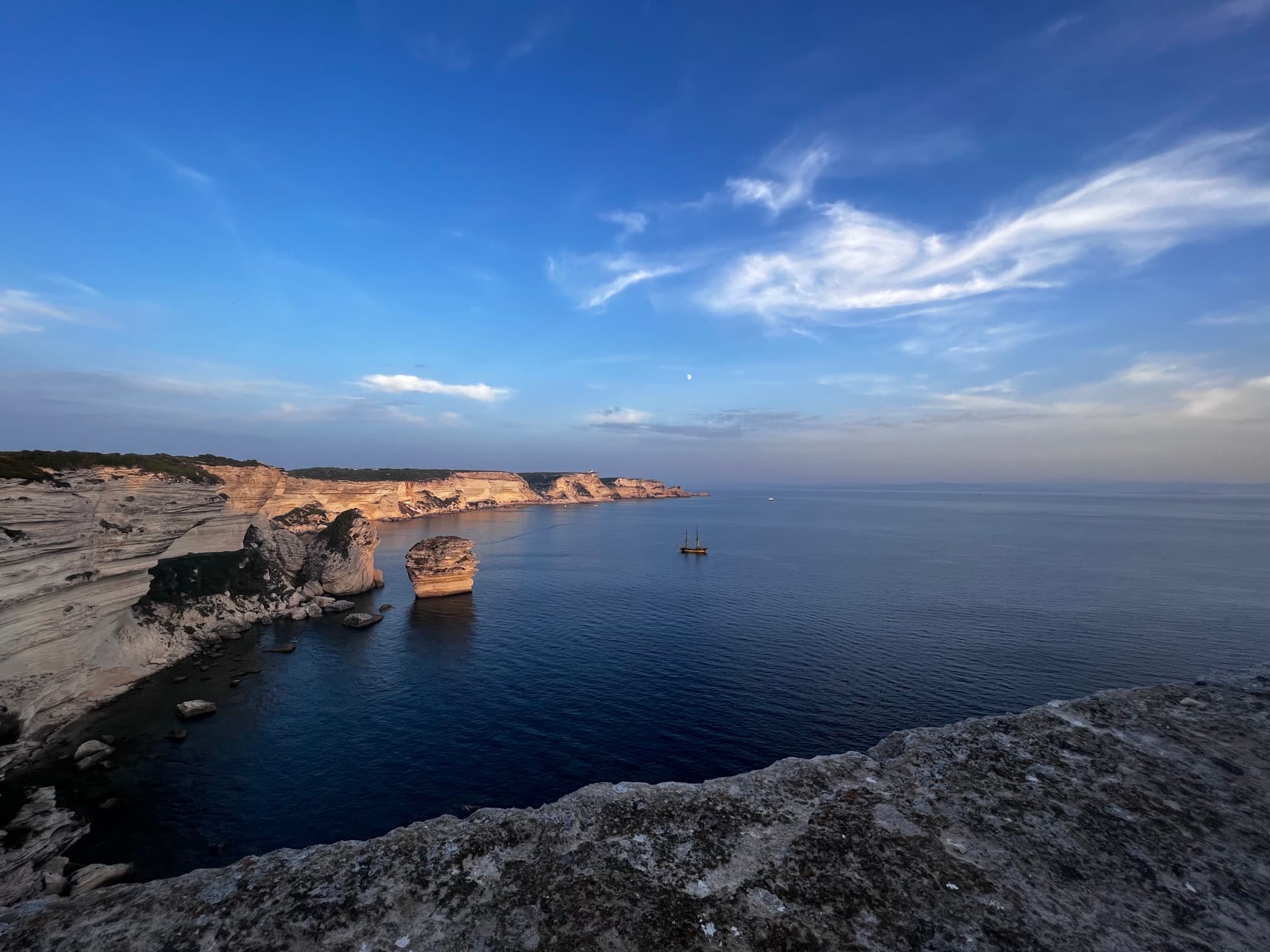 Mediterranean coastline with sailing vessel
